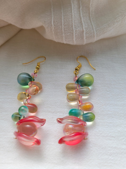 Multicolored glass beads earrings on a white fabric background