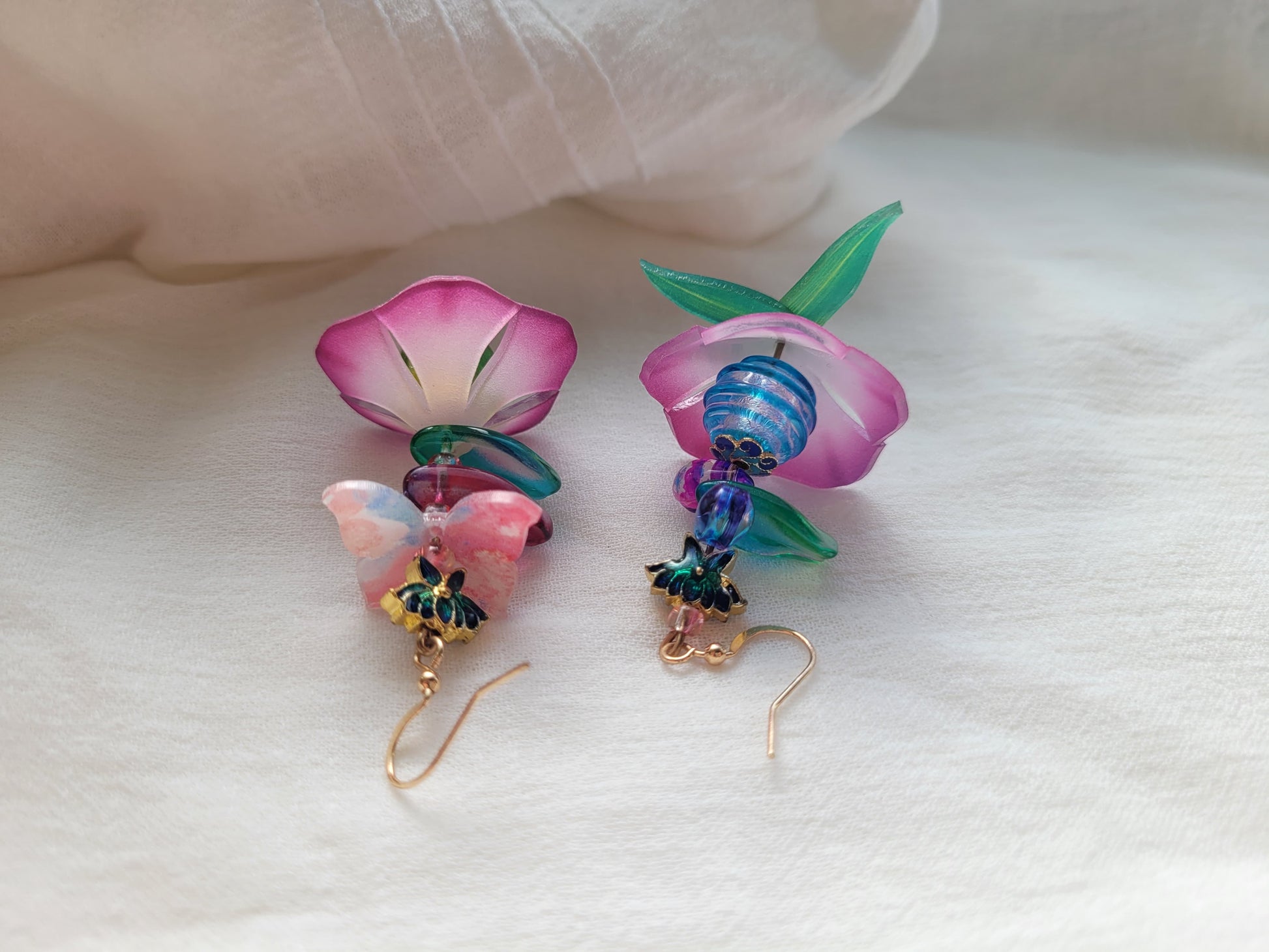 Pair of floral-themed earrings with colorful beads on a white background