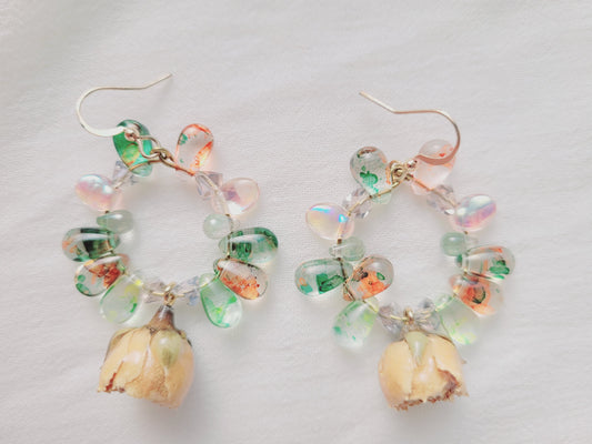 Colorful pastel glass bead earrings with natural yellow roses on a light gray background