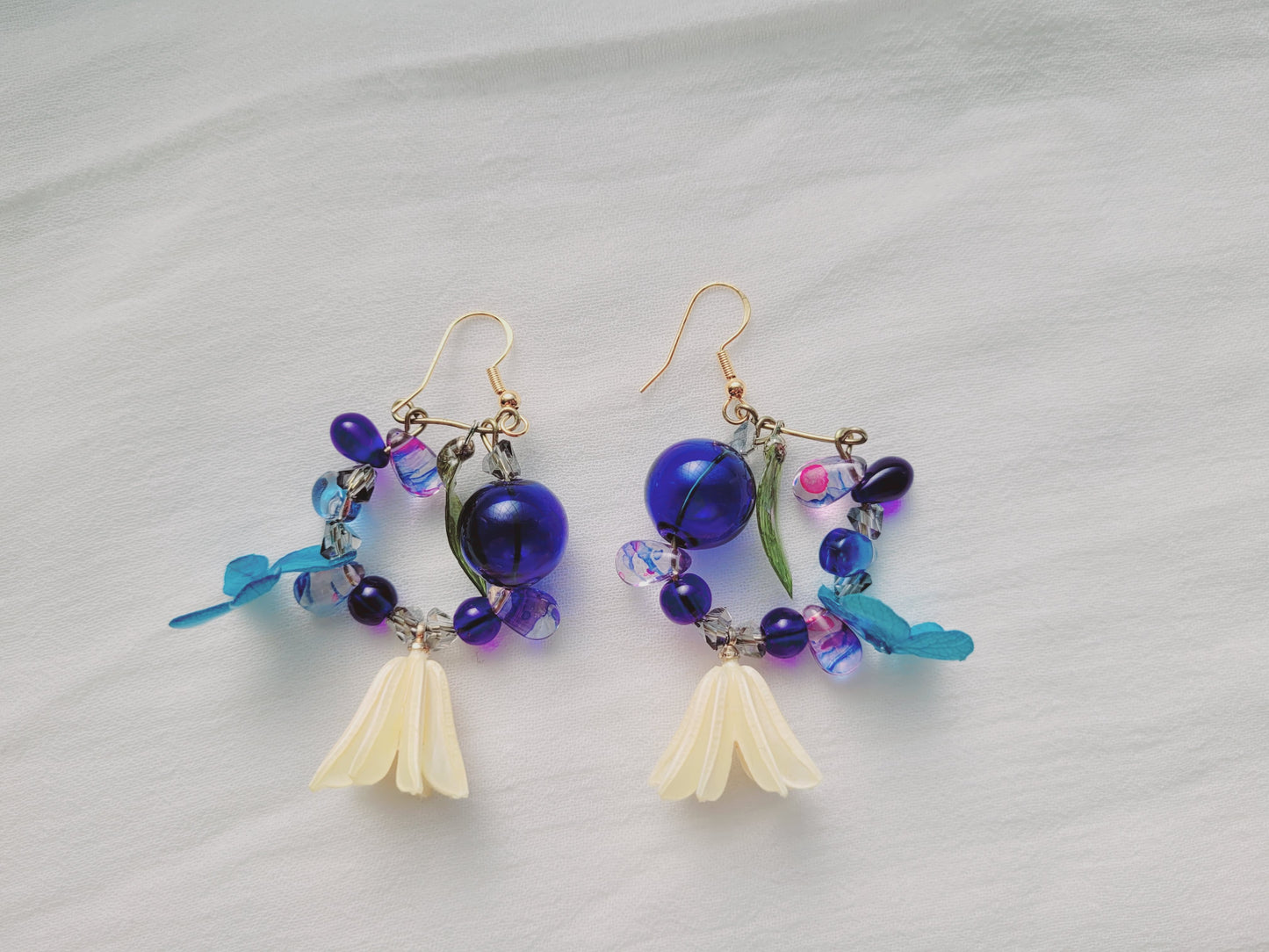 Pair of colorful beaded earrings on a light gray background