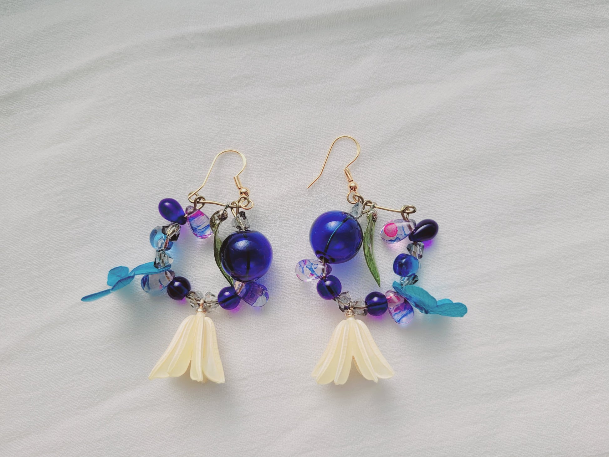 Pair of colorful beaded earrings on a light gray background