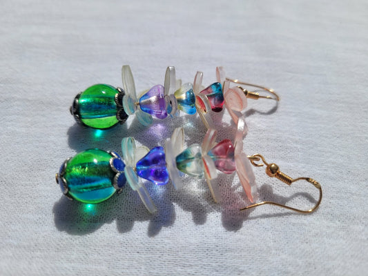 Colorful  glass beads earrings with pale pink and white butterflies and gold plated hooks on a light gray background 